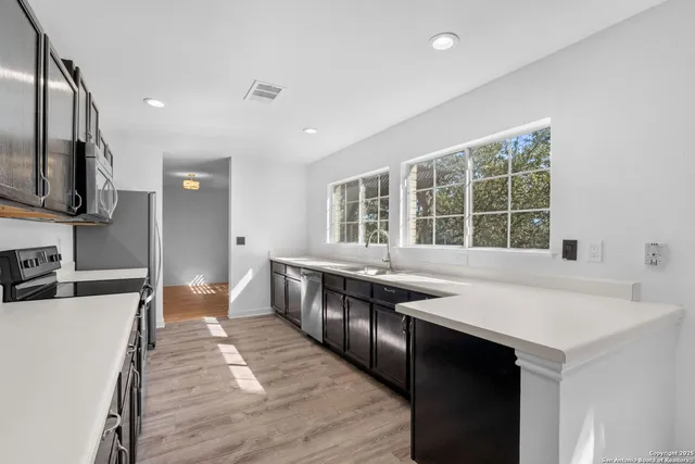 a kitchen with stainless steel appliances granite countertop a sink and stove