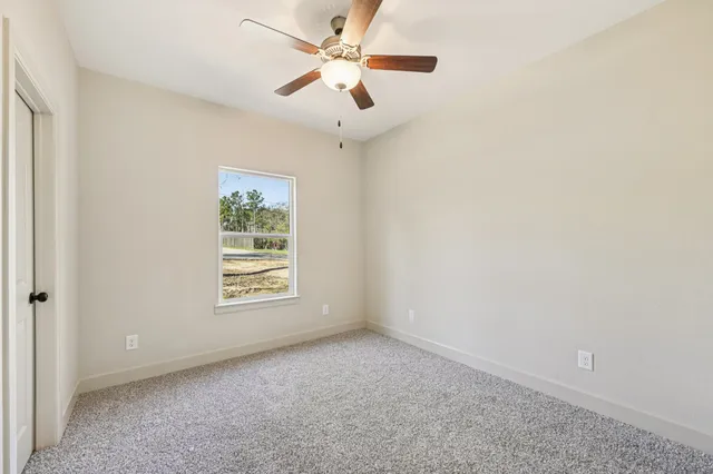 an empty room with a window and a fan