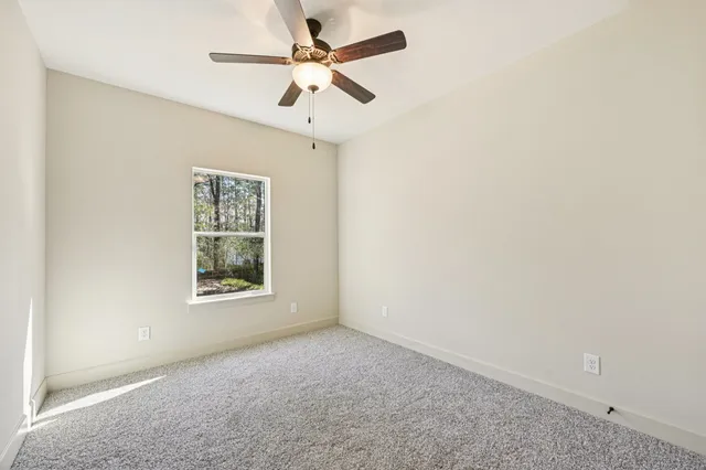an empty room with a window and a fan
