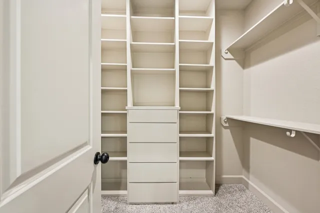 a view of walk in closet with empty racks