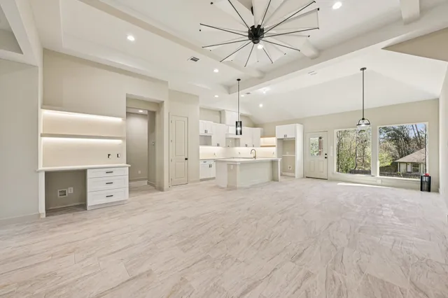 a large white room with a large window and a ceiling fan