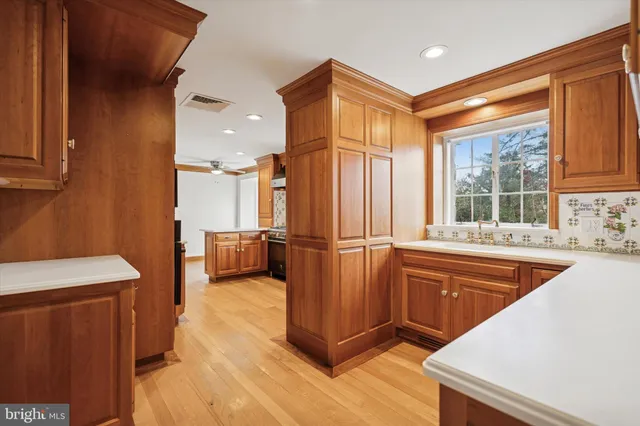 a kitchen with stainless steel appliances granite countertop a refrigerator a sink dishwasher and wooden cabinets with wooden floor