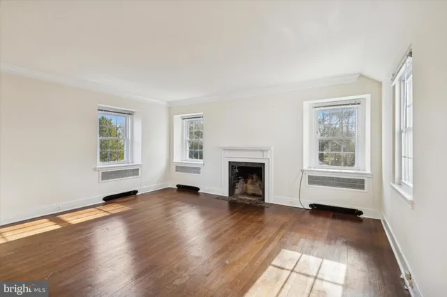 a view of empty room with wooden floor and fireplace