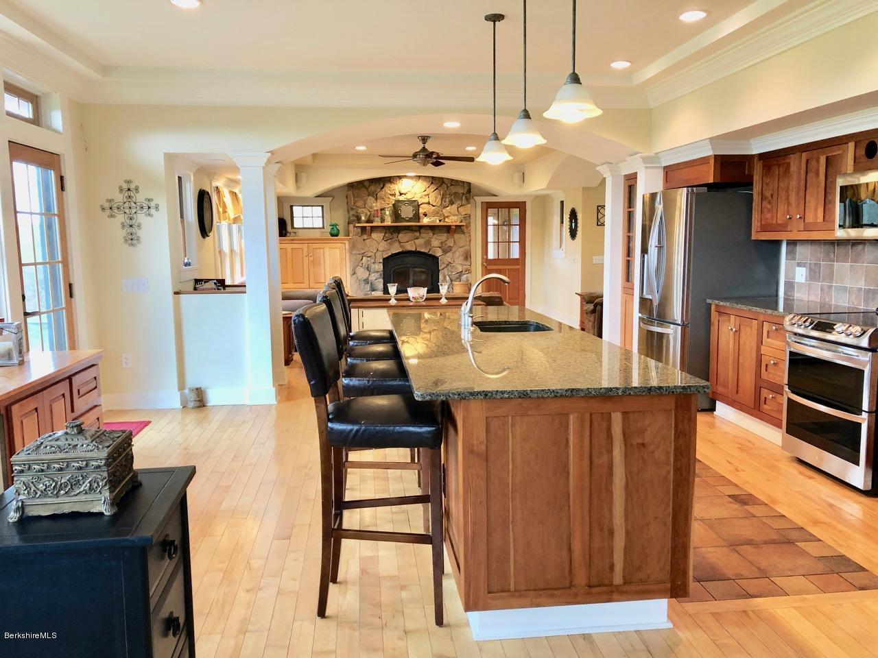 385 W Road Lee, MA 01238 - Photo 13 of 35 a kitchen with stainless steel appliances kitchen island granite countertop a stove a sink dishwasher and a refrigerator with wooden floor
