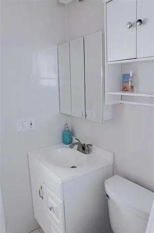 a bathroom with a sink a toilet and vanity