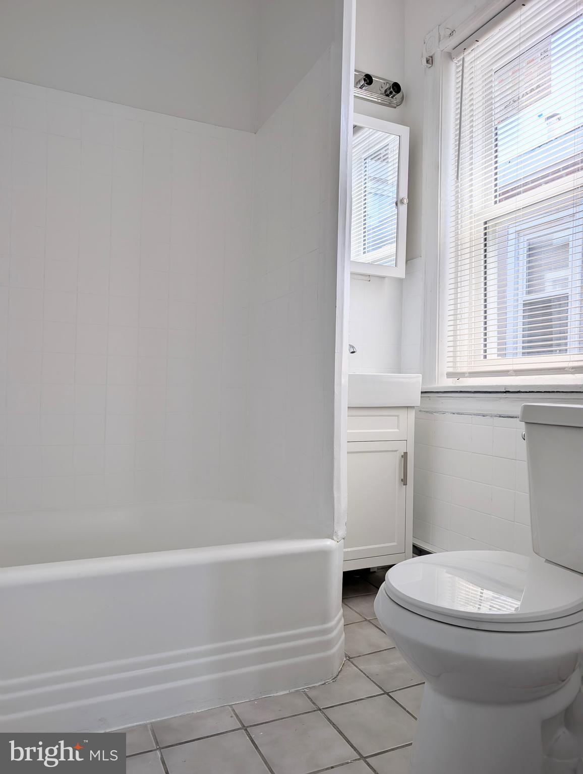 5205 North 5th Street, Unit 2F Philadelphia, PA 19120 - Photo 5 of 6 a bathroom with a toilet and a bathtub