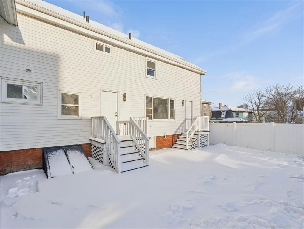 12 Howard Street Lynn, MA 01902 - Photo 22 of 26 a view of roof deck with table and chairs with wooden floor and fence