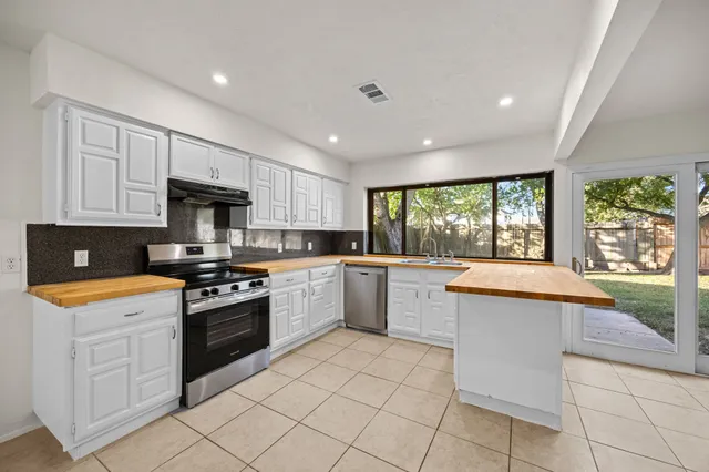 a kitchen with a stove sink and cabinets