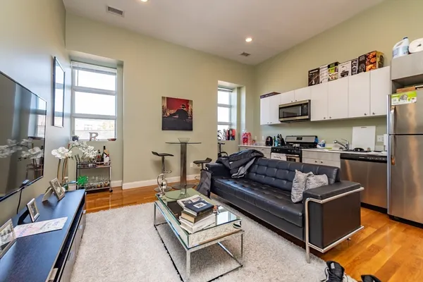 a living room with furniture a flat screen tv and a dining table