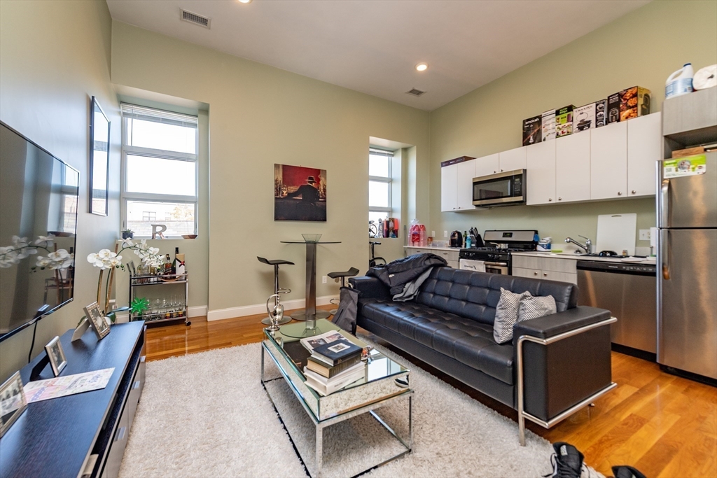 409 Dudley Street Boston, MA 02119 - Photo 7 of 16 a living room with furniture a flat screen tv and a dining table
