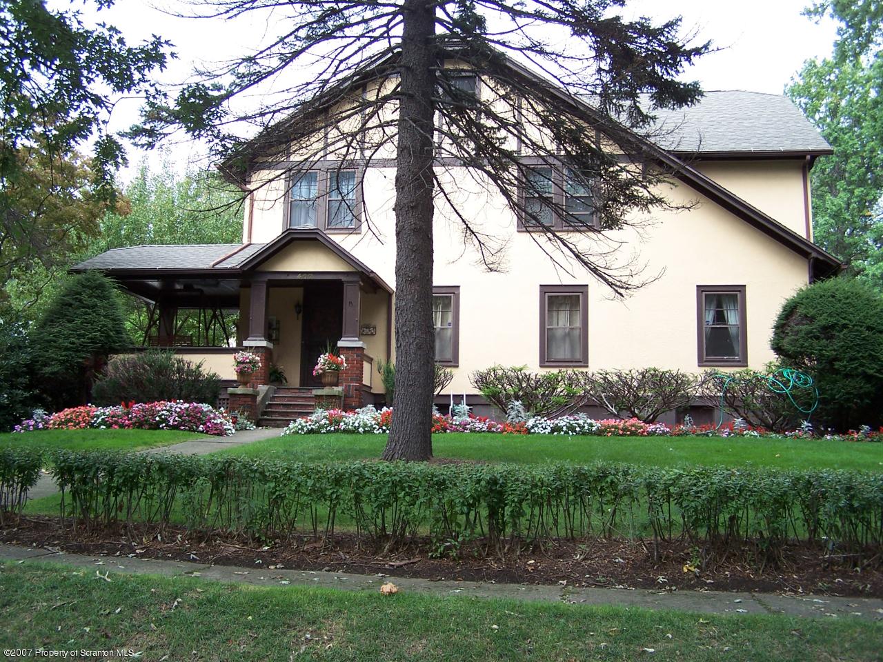 407 Nelson Street Clarks Summit, PA 18411 - Photo 1 of 3 a front view of a house with a garden and trees