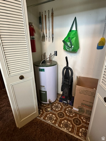 1085 West Elk Road Helper, UT 84526 - Photo 15 of 40 Utility closet featuring a water heater, patterned floor tiles, and bi-fold louvered doors