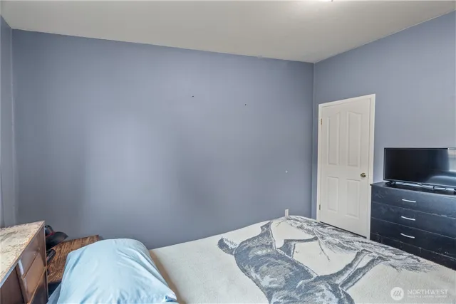 a bedroom with a bed and a flat screen tv