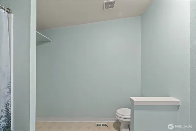 a white toilet sitting next to a shower