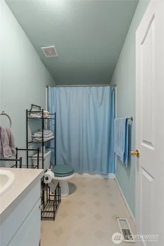 a bedroom with a bed and a table chair