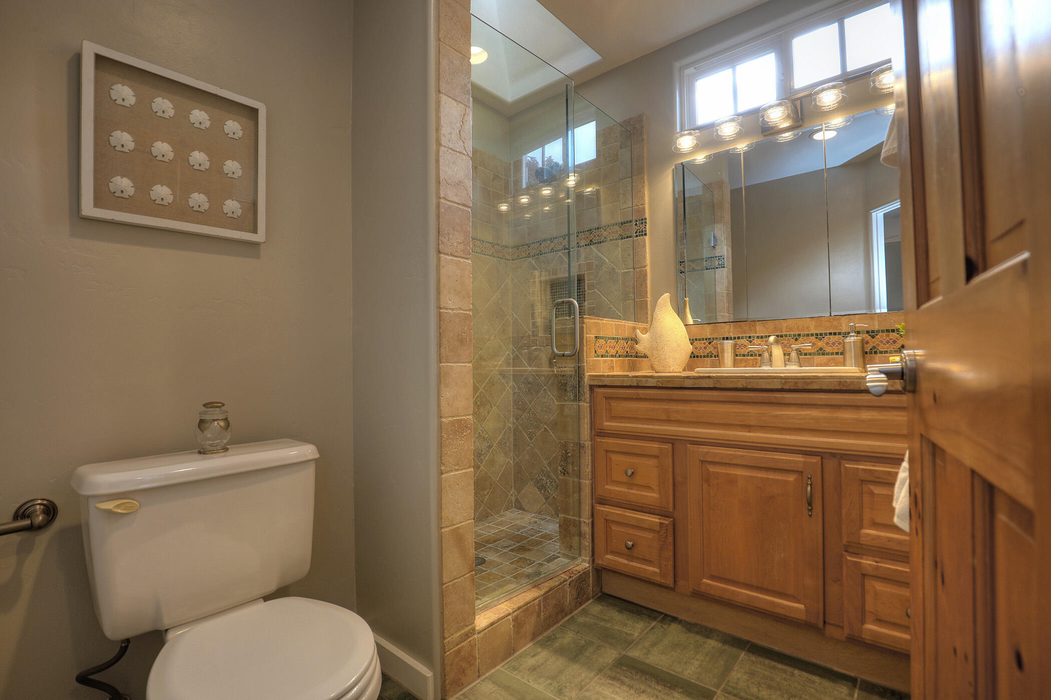 570 Amherst Drive Goleta, CA 93117 - Photo 21 of 31 a bathroom with a toilet a sink and glass door