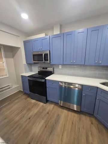 a kitchen with stainless steel appliances granite countertop a sink a stove a microwave a sink and cabinets