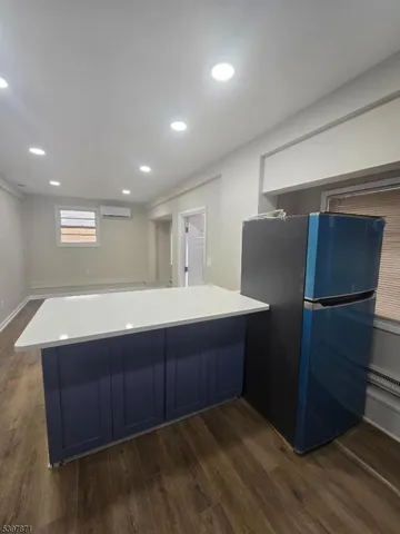 a living room with a dresser and a refrigerator