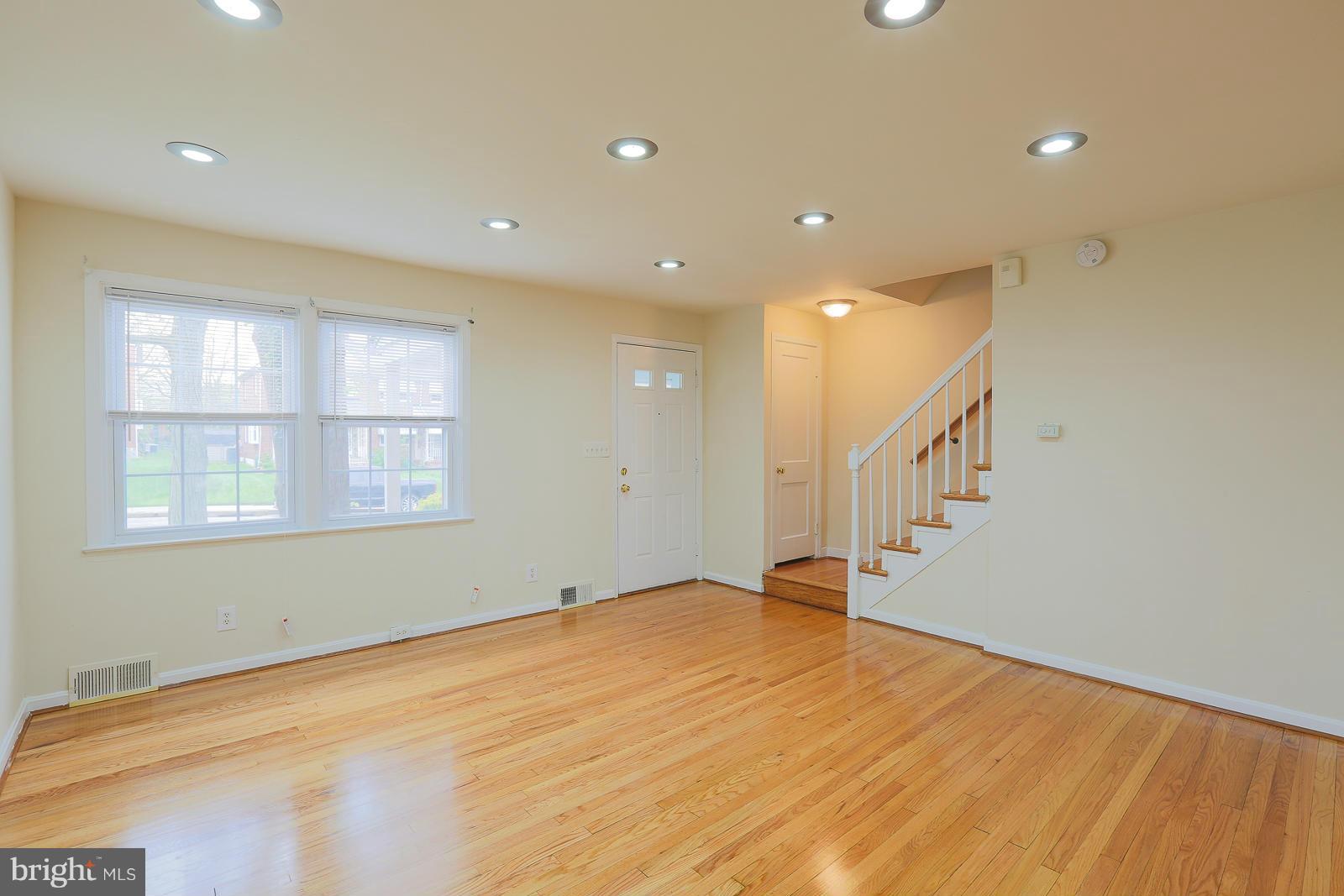 4522 Marble Hall Road Baltimore, MD 21239 - Photo 7 of 28 a view of an empty room with wooden floor and staircase