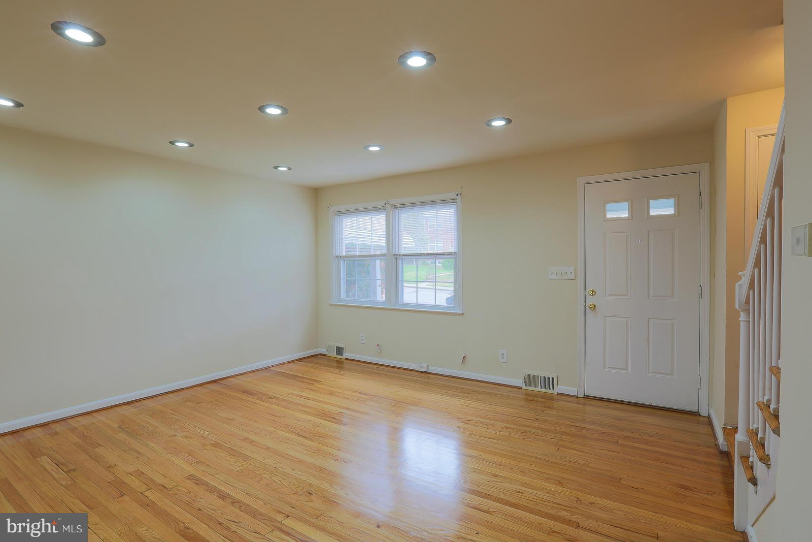 4522 Marble Hall Road Baltimore, MD 21239 - Photo 8 of 28 an empty room with wooden floor and windows
