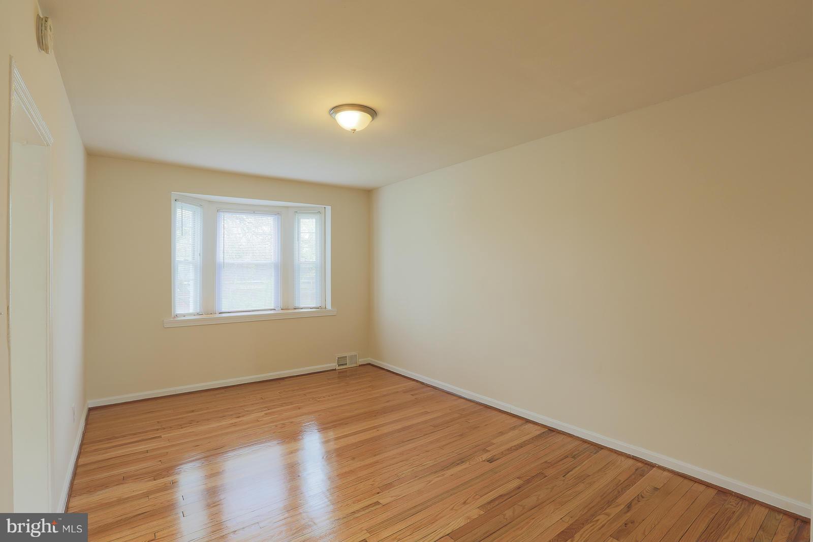 4522 Marble Hall Road Baltimore, MD 21239 - Photo 10 of 28 a view of an empty room with wooden floor and a window
