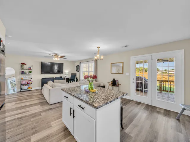 a view of living room kitchen with granite countertop living room and fireplace