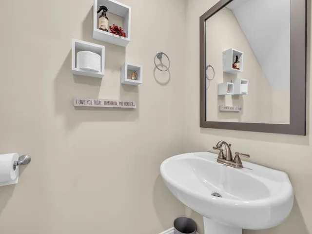 a bathroom with a sink and mirror with window