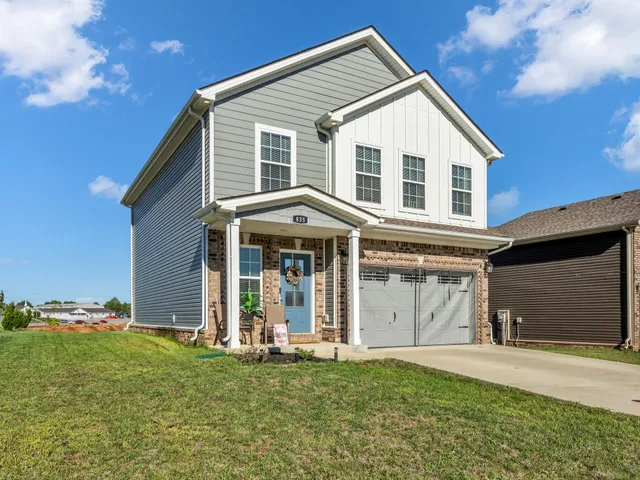 a view of a house with a yard and garage