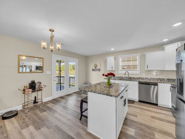 a kitchen with granite countertop cabinets stove and center island