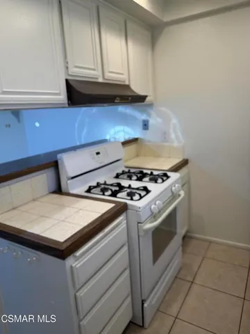 a kitchen with granite countertop a stove and a sink