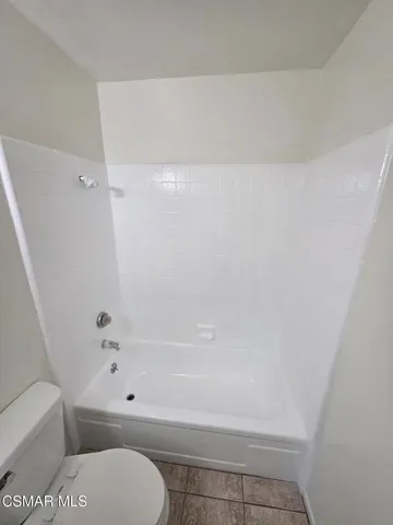 a bathroom with a toilet and a bath tub