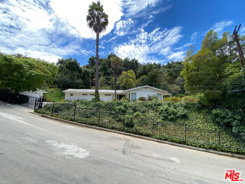 9748 Oak Pass Road Beverly Hills, CA 90210 - Photo 1 of 20 a view of a street with a building in the background