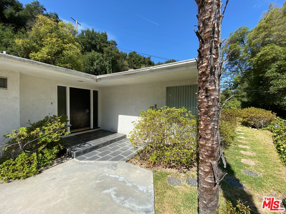 9748 Oak Pass Road Beverly Hills, CA 90210 - Photo 3 of 20 a front view of a house with garden