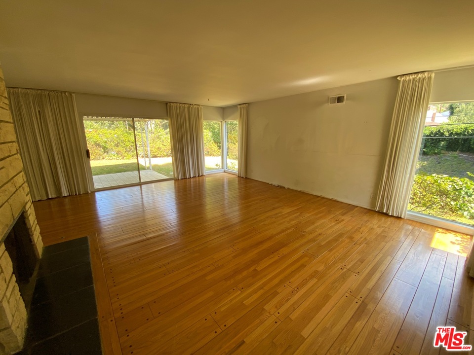 9748 Oak Pass Road Beverly Hills, CA 90210 - Photo 5 of 20 an empty room with wooden floor and windows
