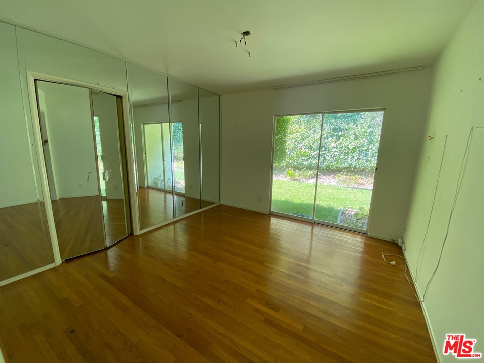 9748 Oak Pass Road Beverly Hills, CA 90210 - Photo 10 of 20 a view of an empty room with wooden floor and a window