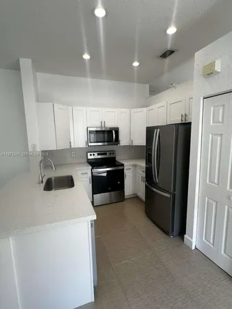 a kitchen with refrigerator a microwave and cabinets