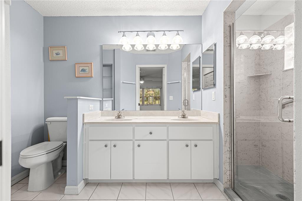 9614 Southwest 93rd Loop Ocala, FL 34481 - Photo 30 of 45 a bathroom with a granite countertop sink a toilet and a large mirror