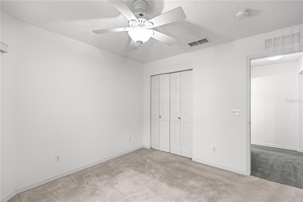 9614 Southwest 93rd Loop Ocala, FL 34481 - Photo 33 of 45 an empty room with a chandelier fan and windows