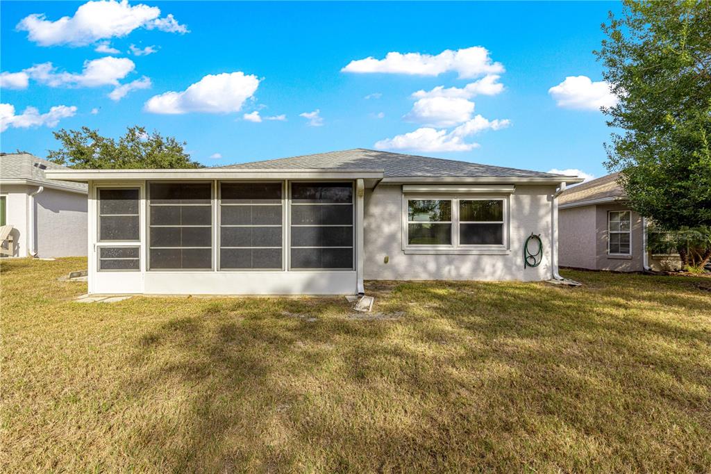 9614 Southwest 93rd Loop Ocala, FL 34481 - Photo 40 of 45 a view of a house with a large window and a large tree