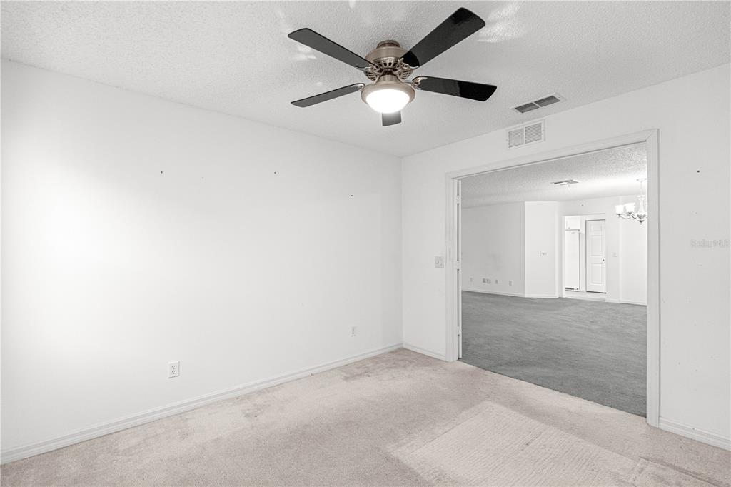 9614 Southwest 93rd Loop Ocala, FL 34481 - Photo 6 of 45 an empty room with a ceiling fan and a rug