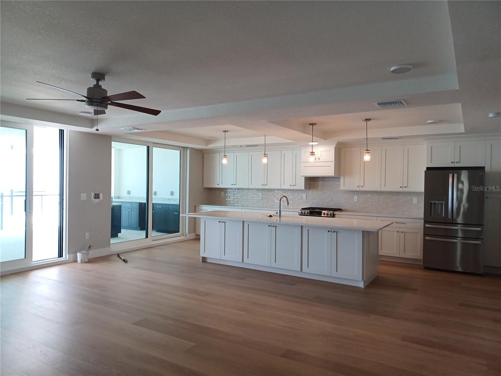 14048 Gulf Boulevard, Unit 402 Madeira Beach, FL 33708 - Photo 3 of 11 a large kitchen with a center island wooden floor stainless steel appliances and cabinets