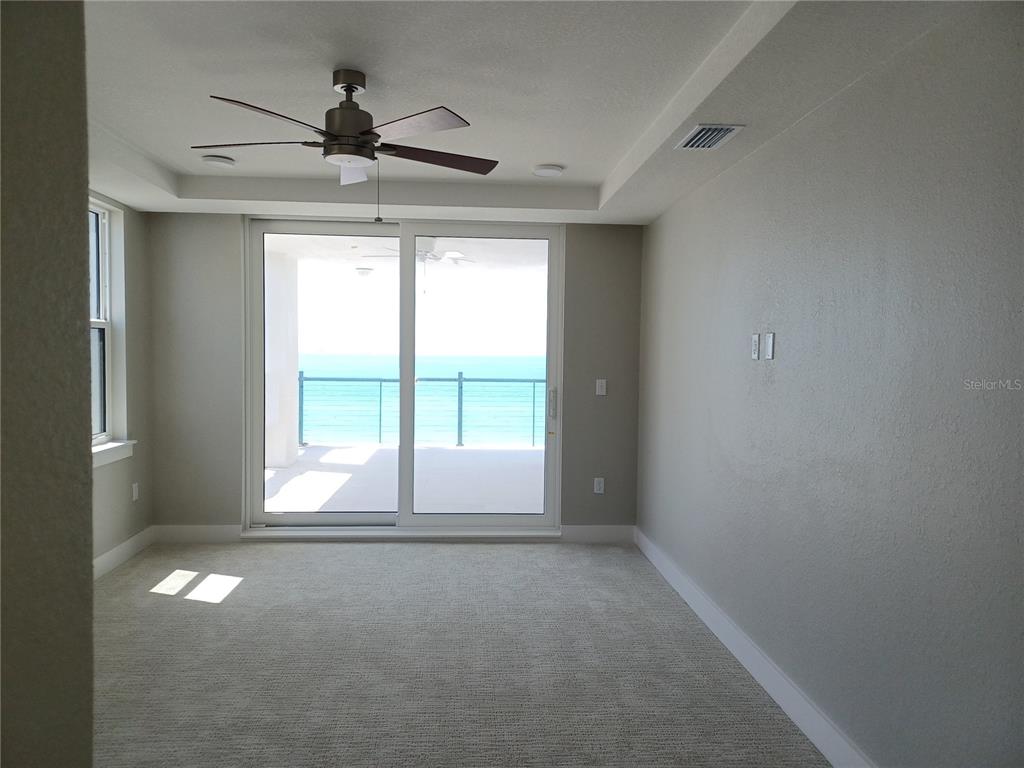 14048 Gulf Boulevard, Unit 402 Madeira Beach, FL 33708 - Photo 5 of 11 a view of empty room with wooden floor and fan