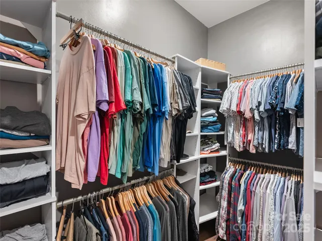 a view of walk in closet with clothes and shoes