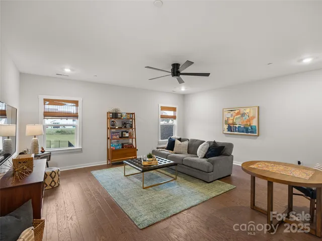 a living room with furniture and a flat screen tv with wooden floor