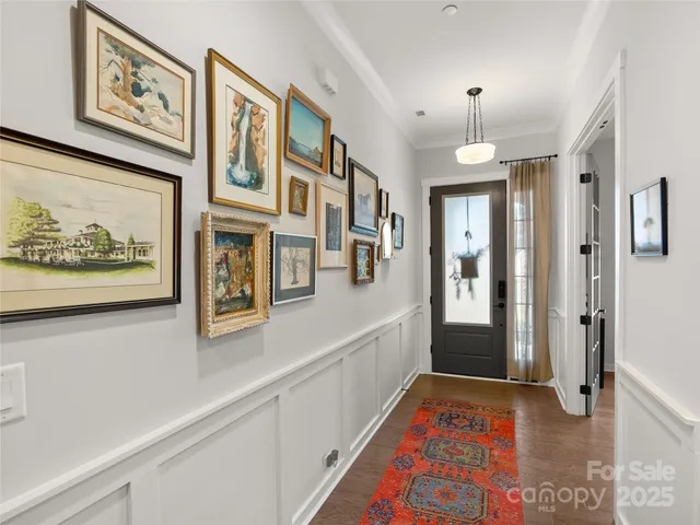 a hallway with painting on the wall and a shower