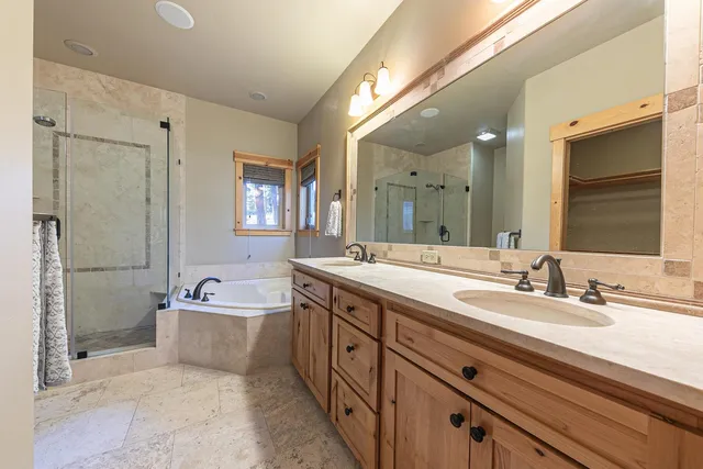 a spacious bathroom with a double vanity sink mirror and bathtub