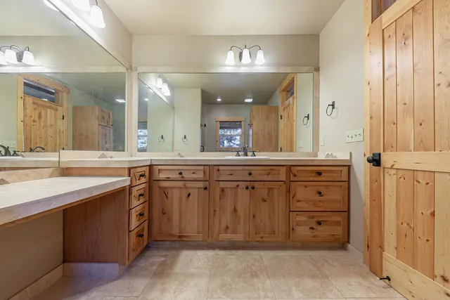 a spacious bathroom with a granite countertop sink and a mirror