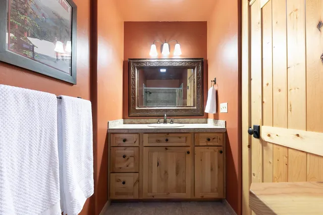 a bathroom with a granite countertop sink and a mirror