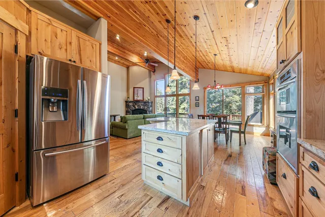 a kitchen with stainless steel appliances a refrigerator and wooden floor