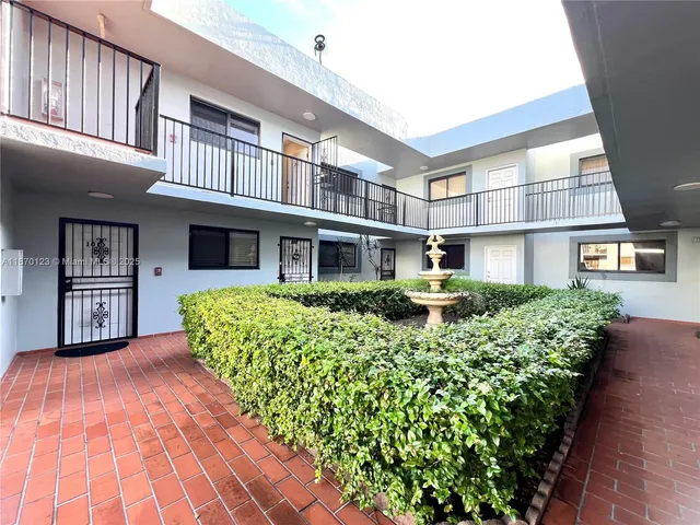 a front view of a building with a garden